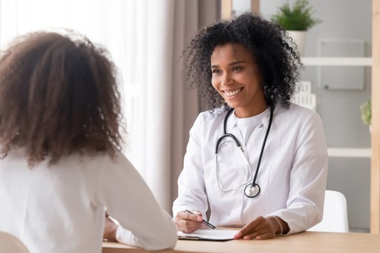 female-african-adult-doctor-consultation-room-taking-notes-while-talking-with-patient-web