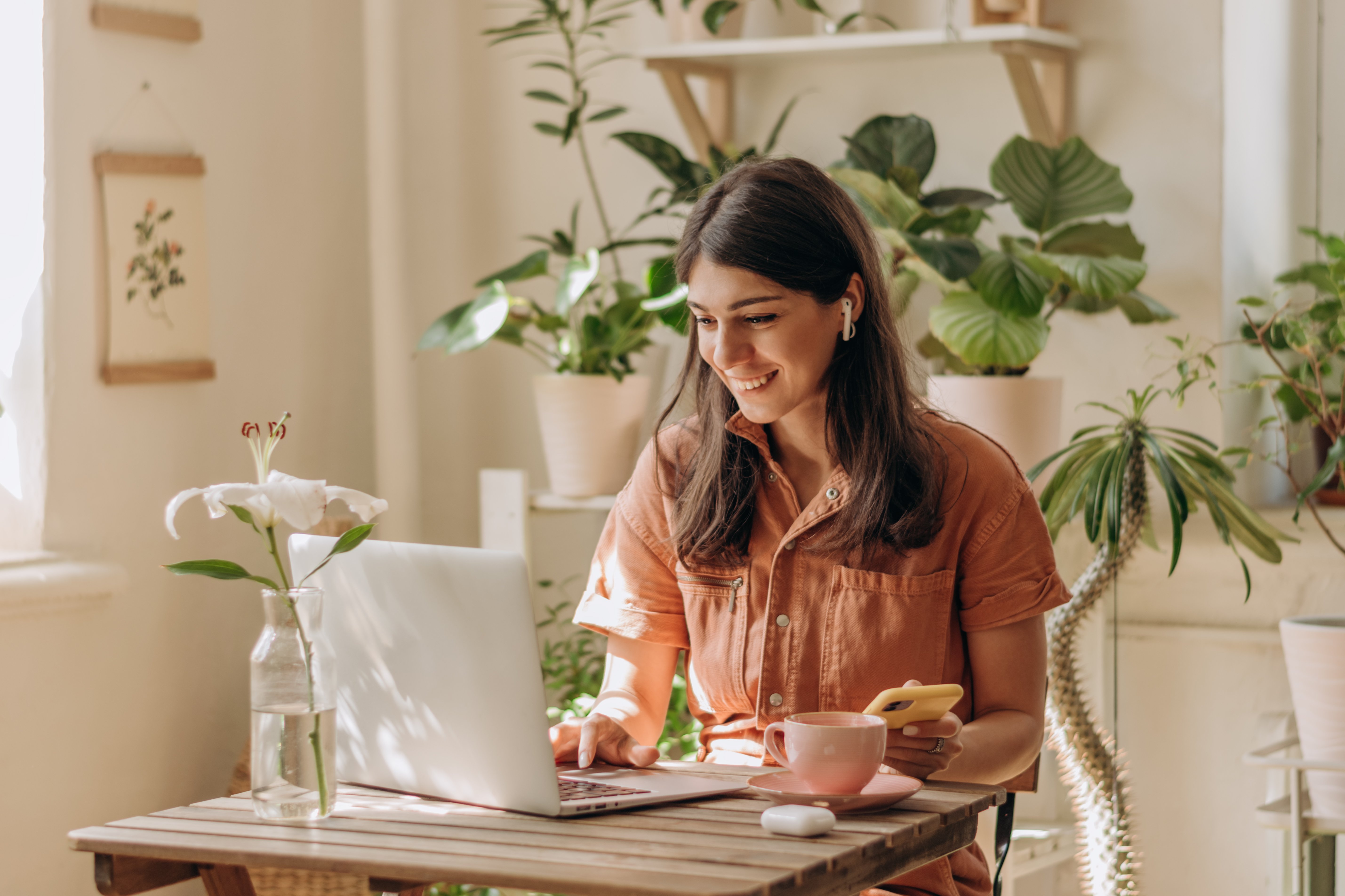 female-european-adult-indoor-using-a-laptop-and-smartphone-while-working-online-web