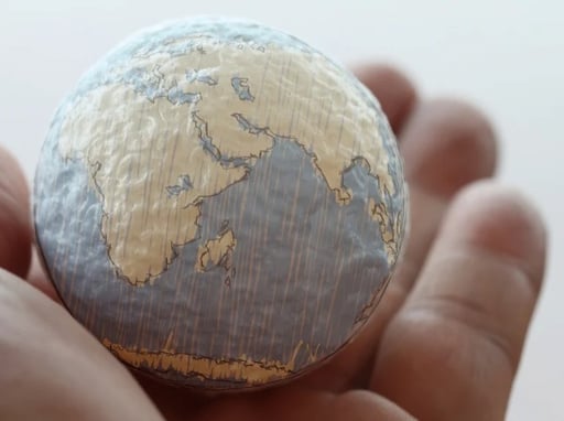 close up of a paper world in a hand of a person